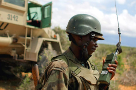 Un commandant de l’AMISOM devant un véhicule de transport de troupes blindé.